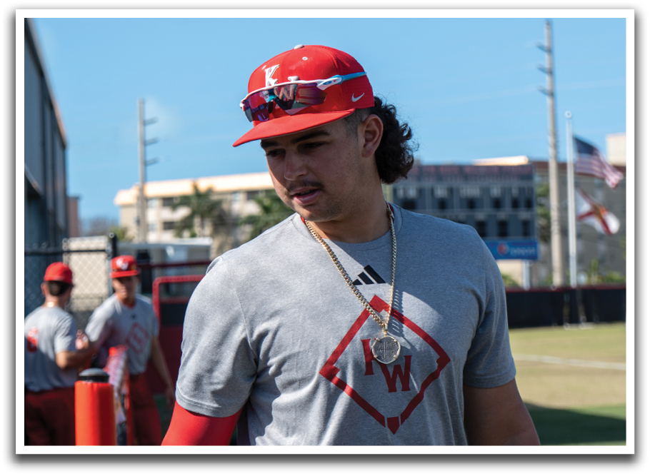 A man wearing a baseball uniform with a red hat and red pants. Description generated by AI