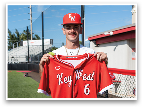 A man wearing a red and white baseball jersey with the number 6 on it. Description generated by AI