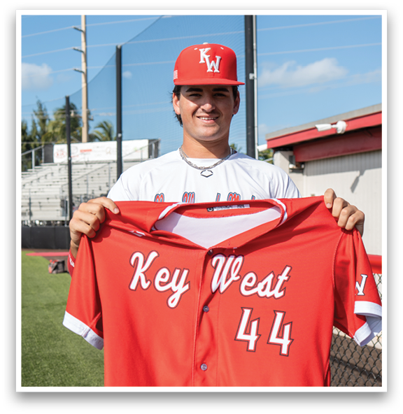 A man wearing a red and white baseball jersey with the number 44 on it. Description generated by AI