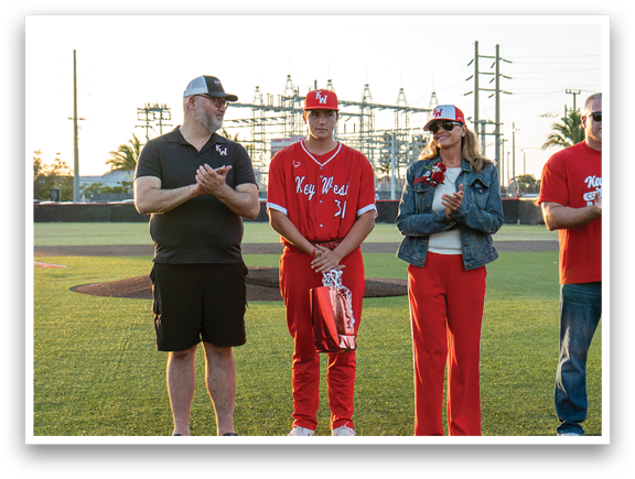 A group of people standing on a baseball field. Description generated by AI