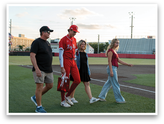 Three people walking on a baseball field. Description generated by AI