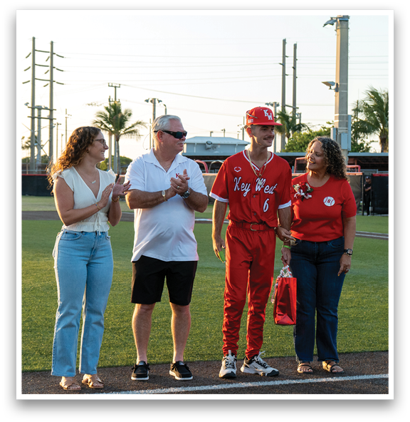 A man in a red baseball uniform is being congratulated by a group of people. Description generated by AI