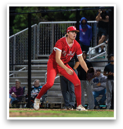 A baseball player in a red uniform is standing on the field. Description generated by AI