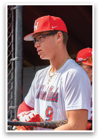 A baseball player wearing a red and white uniform. Description generated by AI