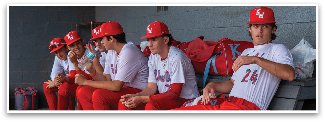 A group of baseball players sitting on a bench. Description generated by AI
