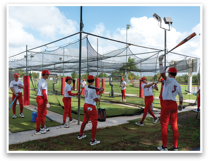 A group of people in red and white uniforms are practicing baseball. Description generated by AI