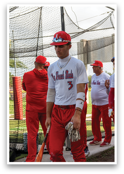 A man wearing a red baseball uniform with a bat. Description generated by AI