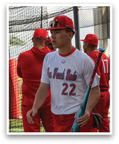 A baseball player wearing a red shirt and red pants. Description generated by AI
