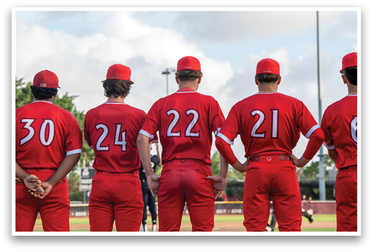 A group of baseball players wearing red uniforms. Description generated by AI