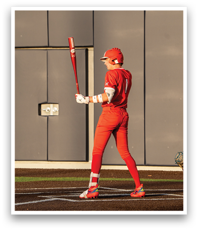 A baseball player in a red jersey holding a bat. Description generated by AI
