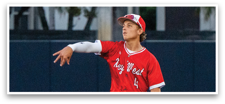A baseball player in a red jersey and red pants is standing on a baseball field. Description generated by AI