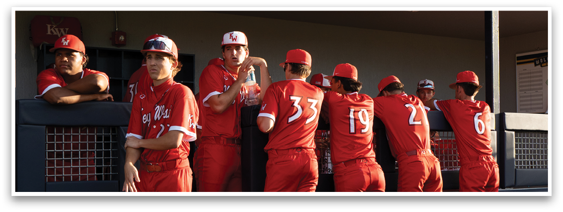 A group of baseball players wearing red uniforms. Description generated by AI