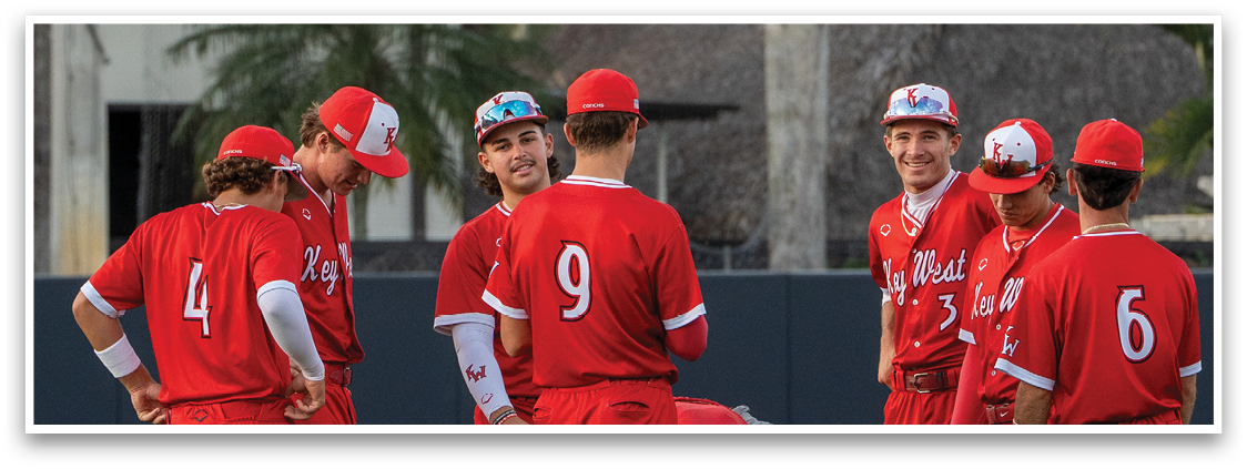 A group of baseball players wearing red uniforms. Description generated by AI