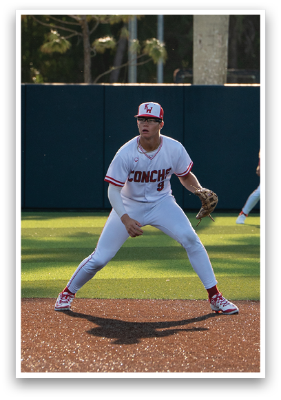 A baseball player in a white uniform is crouching on the field. Description generated by AI