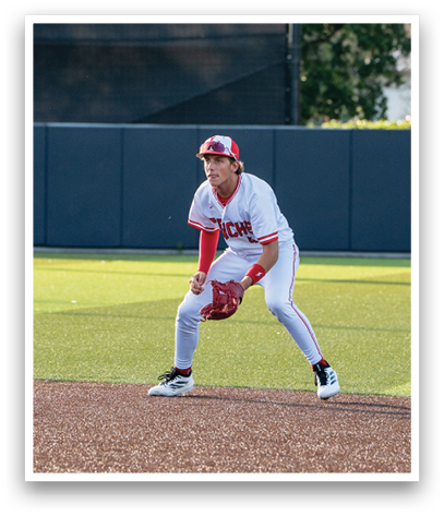 A baseball player wearing a red and white uniform is crouching on the field. Description generated by AI
