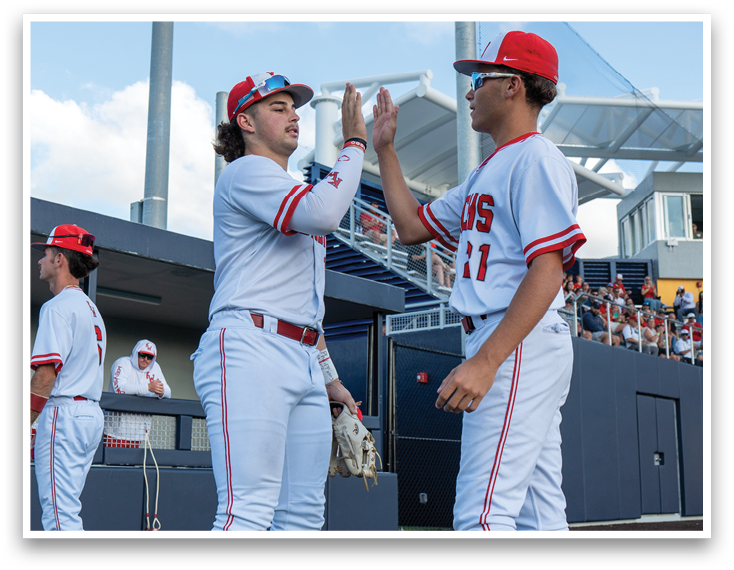 Two baseball players wearing red socks and white uniforms. Description generated by AI