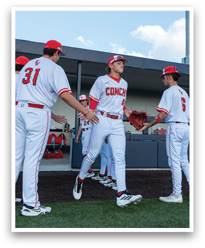 A group of baseball players wearing white uniforms. Description generated by AI
