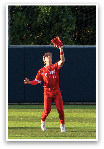 A baseball player wearing a red jersey and red hat catching a ball. Description generated by AI