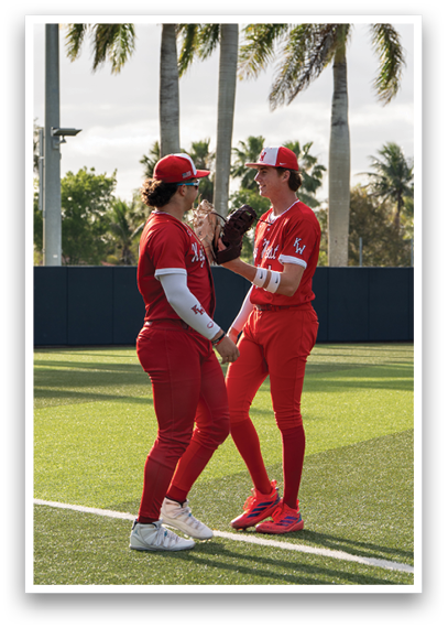 Two baseball players wearing red uniforms and red and white caps. Description generated by AI