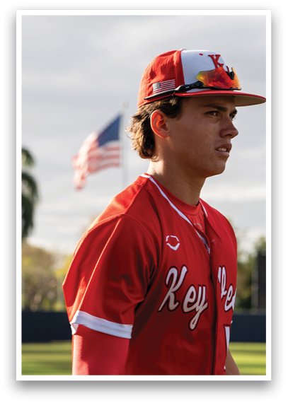 A baseball player wearing a red and white jersey. Description generated by AI