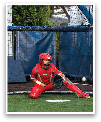 A baseball player in a red uniform is squatting down and holding a baseball glove. Description generated by AI