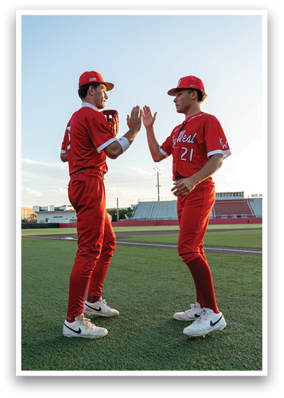 Two baseball players wearing red uniforms and white shoes. Description generated by AI