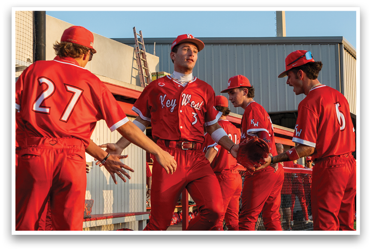 A group of baseball players wearing red uniforms. Description generated by AI