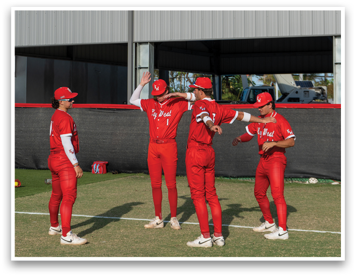 A group of people wearing red and white uniforms are standing on a baseball field. Description generated by AI