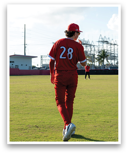 A baseball player wearing a red jersey with the number 26 on it. Description generated by AI