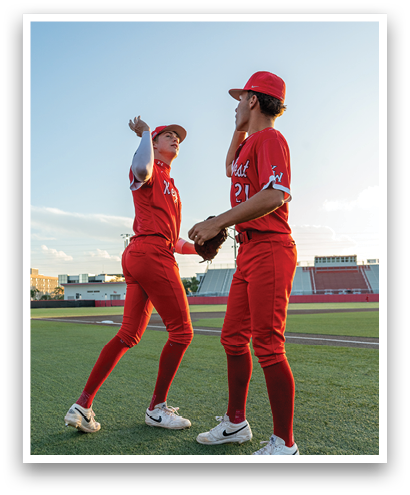 Two men wearing red shirts and red pants. Description generated by AI