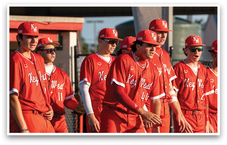 A group of men wearing red jerseys and red hats. Description generated by AI