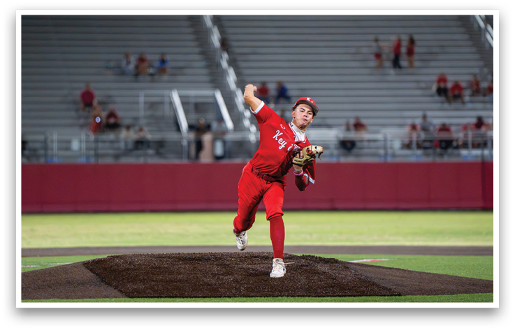 A baseball player in a red uniform is pitching a ball. Description generated by AI
