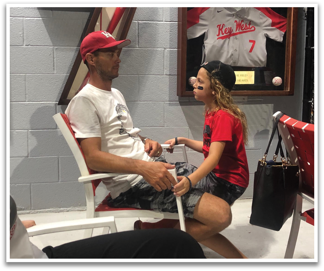 A man and woman are sitting in chairs, with the woman painting the man's fingernails. AI generated content