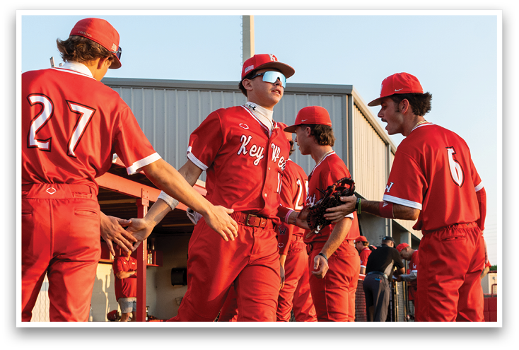 A group of baseball players wearing red uniforms. Description generated by AI