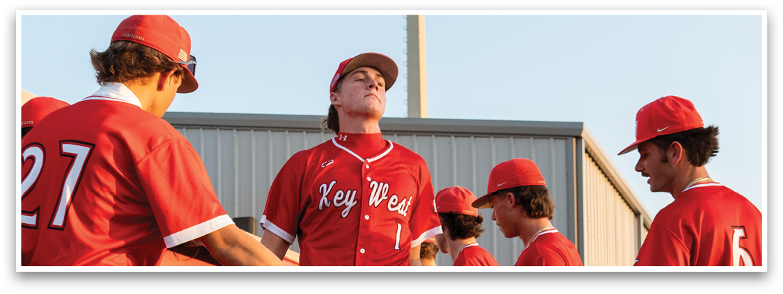 A group of baseball players wearing red uniforms. Description generated by AI