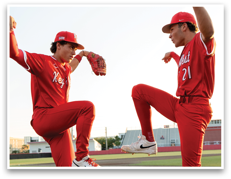 Two baseball players in red uniforms are posing for a picture. Description generated by AI