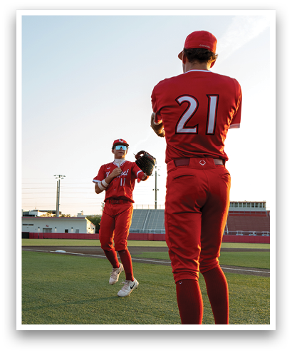 Two baseball players wearing red uniforms. Description generated by AI