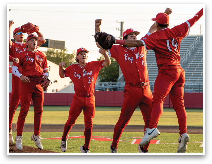 A group of baseball players wearing red uniforms jumping in the air. Description generated by AI