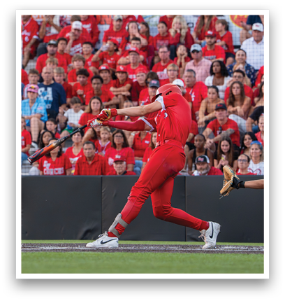 A baseball player in a red shirt and red pants swinging a bat. Description generated by AI