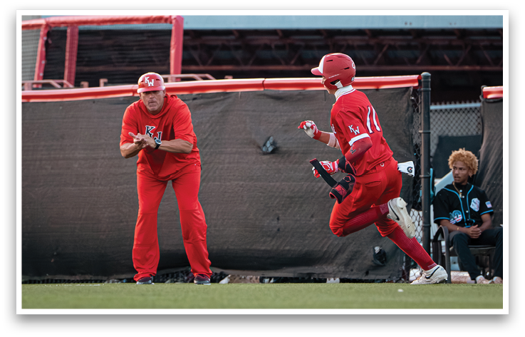 A baseball player in a red uniform is running to a base. Description generated by AI