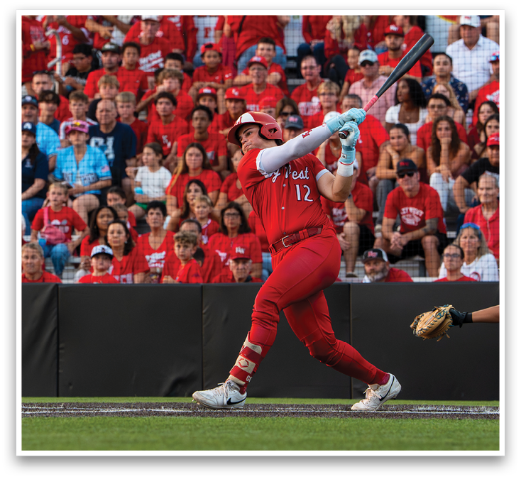 A baseball player in a red shirt and red pants is swinging a bat. Description generated by AI
