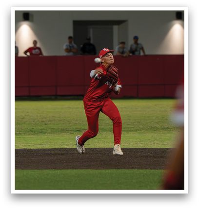 A baseball player in a red uniform is running to first base. Description generated by AI