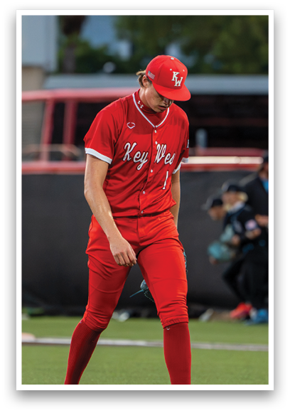 A baseball player wearing a red jersey and red socks. Description generated by AI