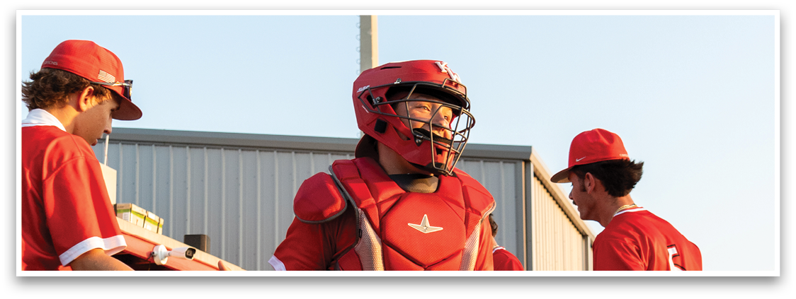 A baseball player wearing a red uniform and a helmet. Description generated by AI