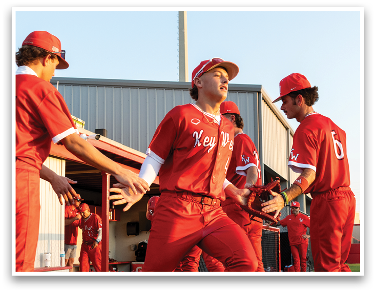 A group of people wearing red jerseys and white shoes. Description generated by AI
