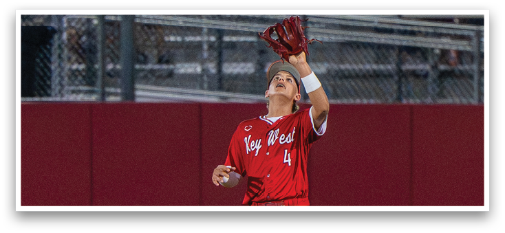 A baseball player in a red uniform catching a ball. Description generated by AI