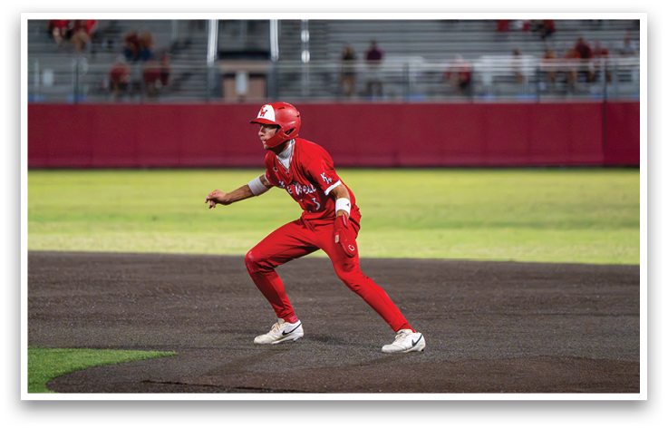 A baseball player wearing a red uniform and a helmet. Description generated by AI