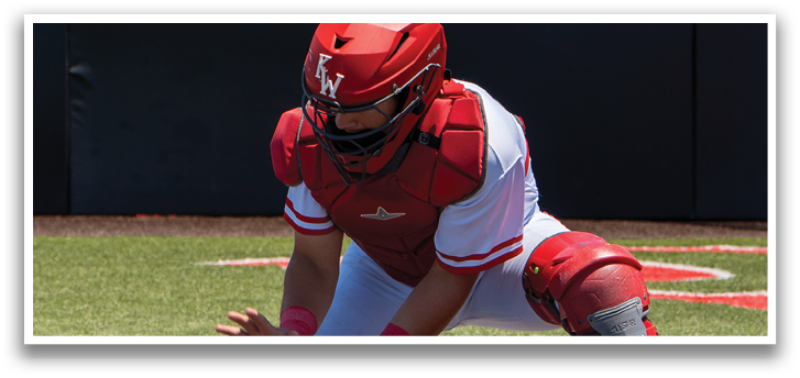 A baseball player in a red and white uniform is kneeling on the ground. Description generated by AI