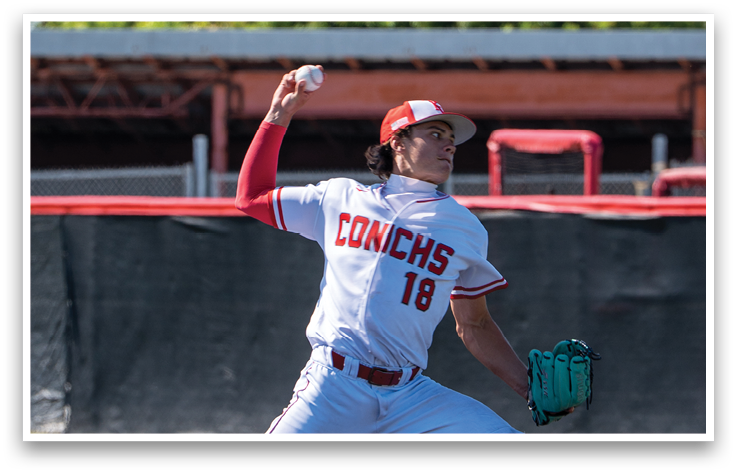 A baseball player in a white and red uniform is pitching a ball. Description generated by AI