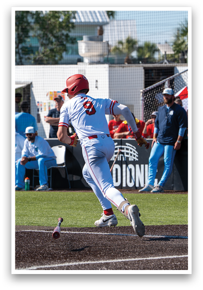 A baseball player wearing a red helmet and white uniform is swinging a bat. Description generated by AI